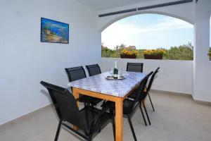 a dining room with a table and chairs and a window at Vito in Bibinje