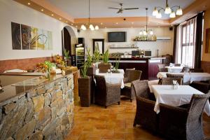 a restaurant with tables and chairs and a stone wall at Hotel Arte in Brno