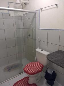 uma casa de banho com um WC e uma cabina de duche em vidro. em Porto dos Lencóis - Chalé Tipo Apartamento em Barreirinhas