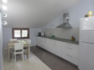 a kitchen with a table and a white refrigerator at Caserio Ipintza Berri in Abaltzisketa