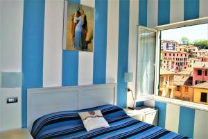 una camera da letto con pareti a strisce blu e un letto con finestra di Levante Blu a La Spezia