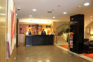 un vestíbulo con dos hombres parados en un mostrador en Hotel Principe Lisboa, en Lisboa