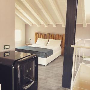 a bedroom with a bed and a refrigerator at Kibò Urban Lodge Chioggia Adults Only in Chioggia