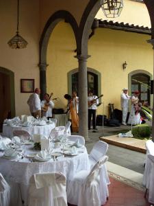 a group of people playing music in a restaurant with white tables at Posada Coatepec in Coatepec