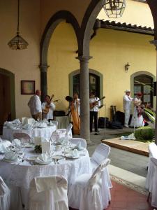 Posada Coatepec في كواتيبيك: مجموعة من الناس يلعبون الموسيقى في مطعم مع طاولات بيضاء