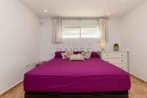 カディスにあるÁtico Plataの白いベッドルーム(窓付)の紫色のベッド1台
