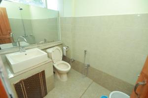 a bathroom with a sink and a toilet and a mirror at Muzaffarabad View Motel in Muzaffarabad