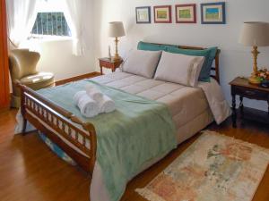 a bedroom with a bed with towels on it at Casa com 2 Quartos em Serra Negra in Serra Negra