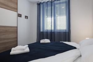 セニにあるApartman Buraの大きなベッドとタオル2枚のある寝室