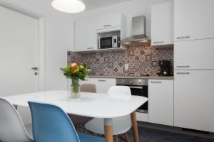 セニにあるApartman Buraのキッチン(白いテーブル、青い椅子付)