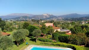 a villa with a swimming pool and mountains in the background at Casa Maria Joana in Ponte de Lima