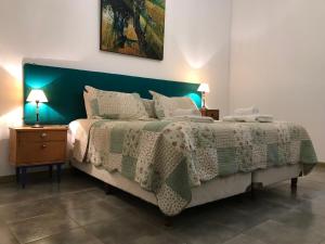 Un dormitorio con una cama grande con cabecero verde. en Molino la Tebaida, en San Martín 45 fotos más