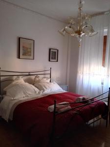 Un dormitorio con una cama con sábanas rojas y una lámpara de araña. en Interno3 en Ancona