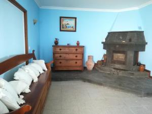 a living room with a couch and a fireplace at Alojamentos A Buraca in São Roque do Pico