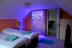 a purple room with a bed and a stone wall at Ett hus med 3 sovrum med supersnabba internet fiberanslutningen 1000mb-100mb i Hög, 7 minuter från Hudiksvall in Hudiksvall