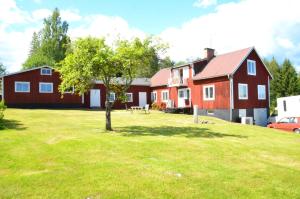 a red house with a tree in the yard at Ett hus med 3 sovrum med supersnabba internet fiberanslutningen 1000mb-100mb i Hög, 7 minuter från Hudiksvall in Hudiksvall