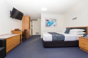 Säng eller sängar i ett rum på West End Motor Lodge