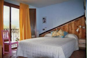 a bedroom with a large bed and a balcony at Los Espinares in Rascafría