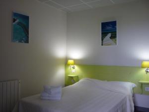 Tempat tidur dalam kamar di West Appart' Hôtel