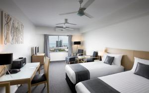Habitación de hotel con 2 camas y escritorio en Mantra Pandanas, en Darwin