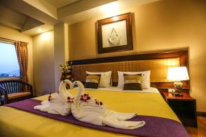 Postel nebo postele na pokoji v ubytování Madina Rayong Hotel