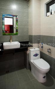 a bathroom with a toilet and a sink and a mirror at Thanh Tu Hotel in Cửa Lô