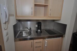 a small kitchen with a sink and a phone at Apart1hotel in Luxembourg