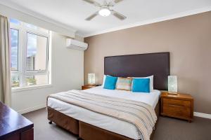 1 dormitorio con 1 cama grande con almohadas azules en BreakFree Moroccan, en Gold Coast