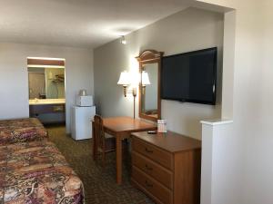 a hotel room with a television and a bed at Countryside Suites Omaha in Omaha