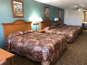 una habitación de hotel con 3 camas en una habitación en Countryside Suites Omaha, en Omaha