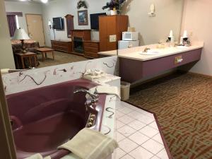 ein Badezimmer mit einer Badewanne und einem Waschbecken in der Unterkunft Countryside Suites Omaha in Omaha