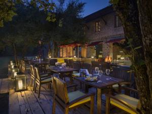 a restaurant with tables and chairs and a fire place at The Tamara Kodai in Kodaikānāl
