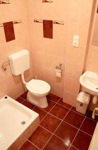 Un baño con inodoro, lavabo y bañera. en Fatornyos Tanyasi Vendégház, en Békéscsaba