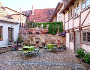 a courtyard with tables and chairs in a building at Hotel garni Tilia in Quedlinburg
