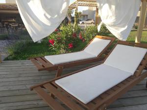 twee ligstoelen op een terras met bloemen bij My Nest Accommodation in Privlaka