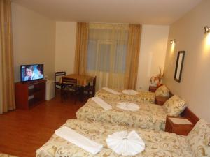 a hotel room with two beds and a television at Matev Hotel in Burgas