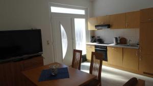 a kitchen with a table with chairs and a television at FeWo in der Villa Gora, in Bergen auf Rügen in Bergen auf Rügen