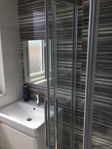 a bathroom with a toilet and a sink and a shower at Rushden Vacation Home in Hendon