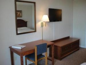 una camera d'albergo con scrivania e specchio di Bryce Inn a Smiths Grove