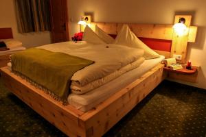 ein großes Bett in einem Zimmer mit einem Holzrahmen in der Unterkunft Appartement Ambrosius in Lermoos