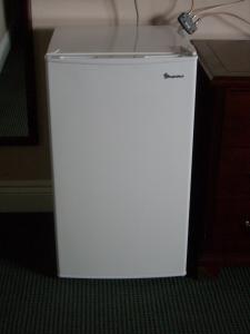 a small white refrigerator sitting in a room at Grand Motel Saint-Hubert in Longueuil