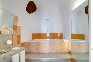 a bathroom with a tub and a shower at Santorini Secret Suites & Spa, Small Luxury Hotels of the World in Oia