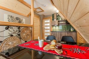 a dining room with a red table with food on it at Apartamenty U Studniara in Murzasichle