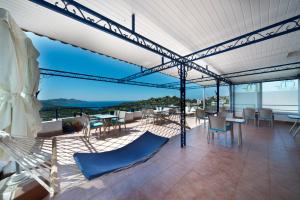 a patio with chairs and tables and a view of the ocean at Miramar Pansiyon in Kaş
