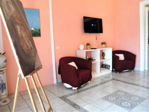 a living room with two chairs and a flat screen tv at Garibaldi Holiday House in Naples