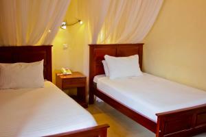 a bedroom with two beds and a telephone in it at Al-Nisaa Hotel and Spa in Jinja +93 photos