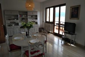 een woonkamer met een tafel met stoelen en een televisie bij Vista Lago Due in Stresa