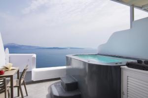 a plunge pool in a white room with a view of the water at Santorini Secret Suites & Spa, Small Luxury Hotels of the World in Oia