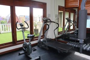 a gym with three elliptical machines and windows at The Vira Bali Boutique Hotel & Suite in Kuta