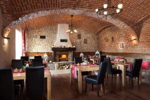 restauracja ze stołami i krzesłami oraz kominkiem w obiekcie Gospodarstwo Agroturystyczne Kowalowe Wzgórze w Polanicy Zdroju